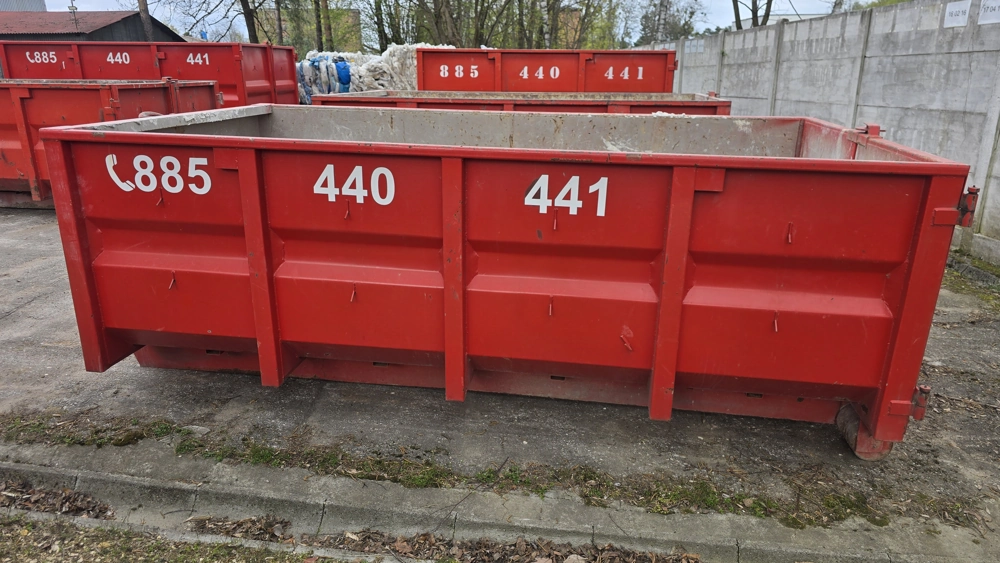 Czerwony metalowy kontener budowlany ustawiony na placu – usługa wynajmu kontenerów na śmieci